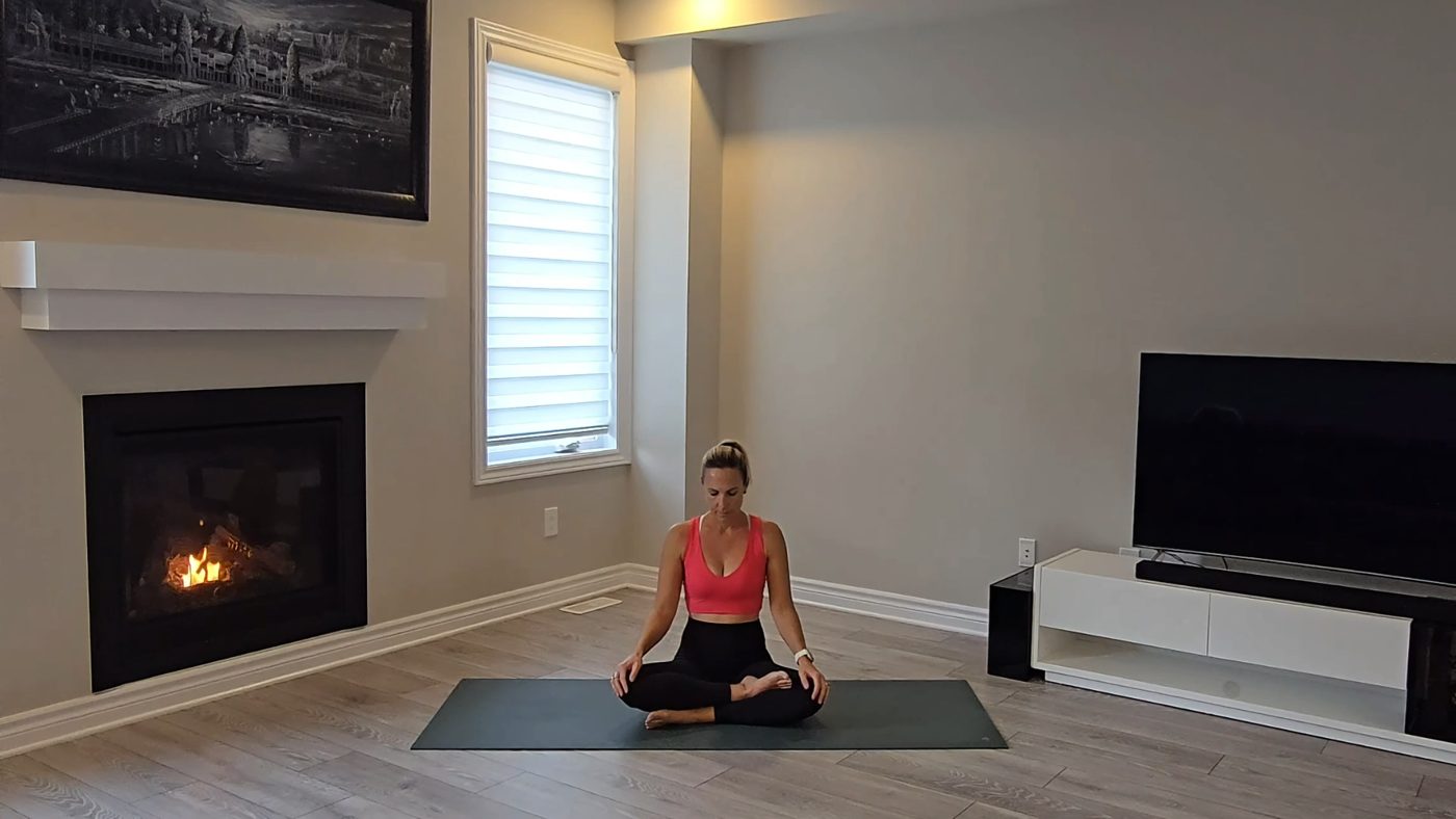 Jen seated in Easy Seat meditation by a fireplace