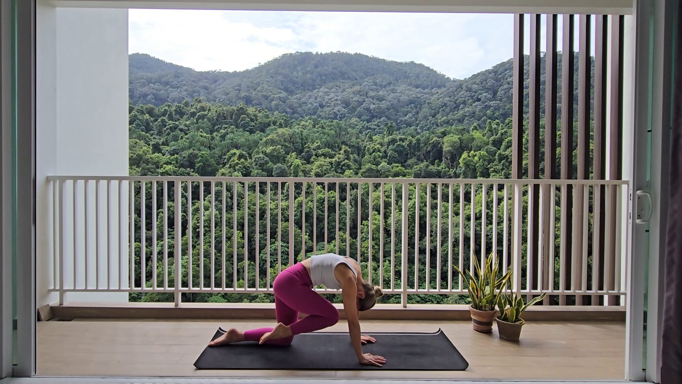 Jen in Triangle Pose on a mountain view terrace